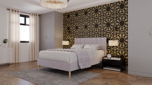 
                  
                    A bed in the middle of a room which has a feature wall of black and gold intricate wallpaper. The bed frame is a dusty pink, with a matching throw over the bed itself. Modern lights hang either side of the bed. 
                  
                