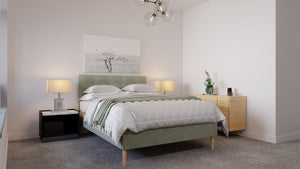 
                  
                    A green modern fabric bed frame in the middle of a room. 
                  
                