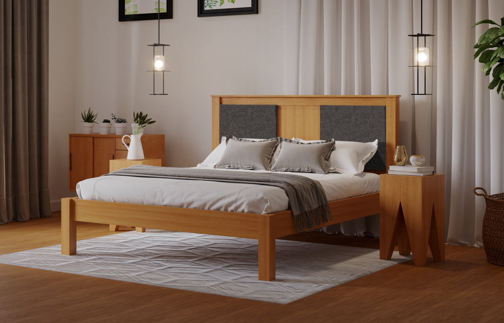 
                  
                    A wooden bed frame with a fabric square either side of the head board. The room has a wooden floor and white walls. 
                  
                