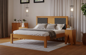 
                  
                    A wooden bed frame with a fabric square either side of the head board. The room has a wooden floor and white walls. 
                  
                