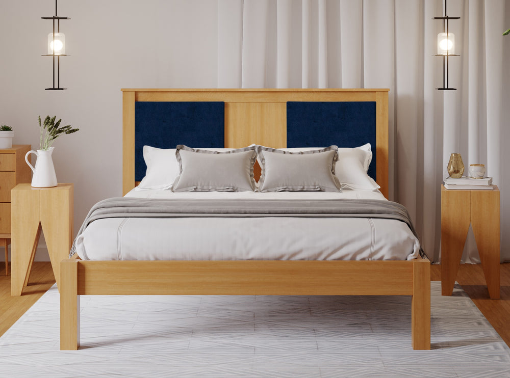 
                  
                    A wooden bed frame with a navy fabric square either side of the head board. The room has a wooden floor and white walls. 
                  
                